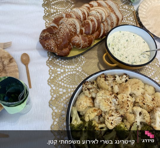 שולחן ערוך עם חלה, סלט, ירקות צלויים ורוטב